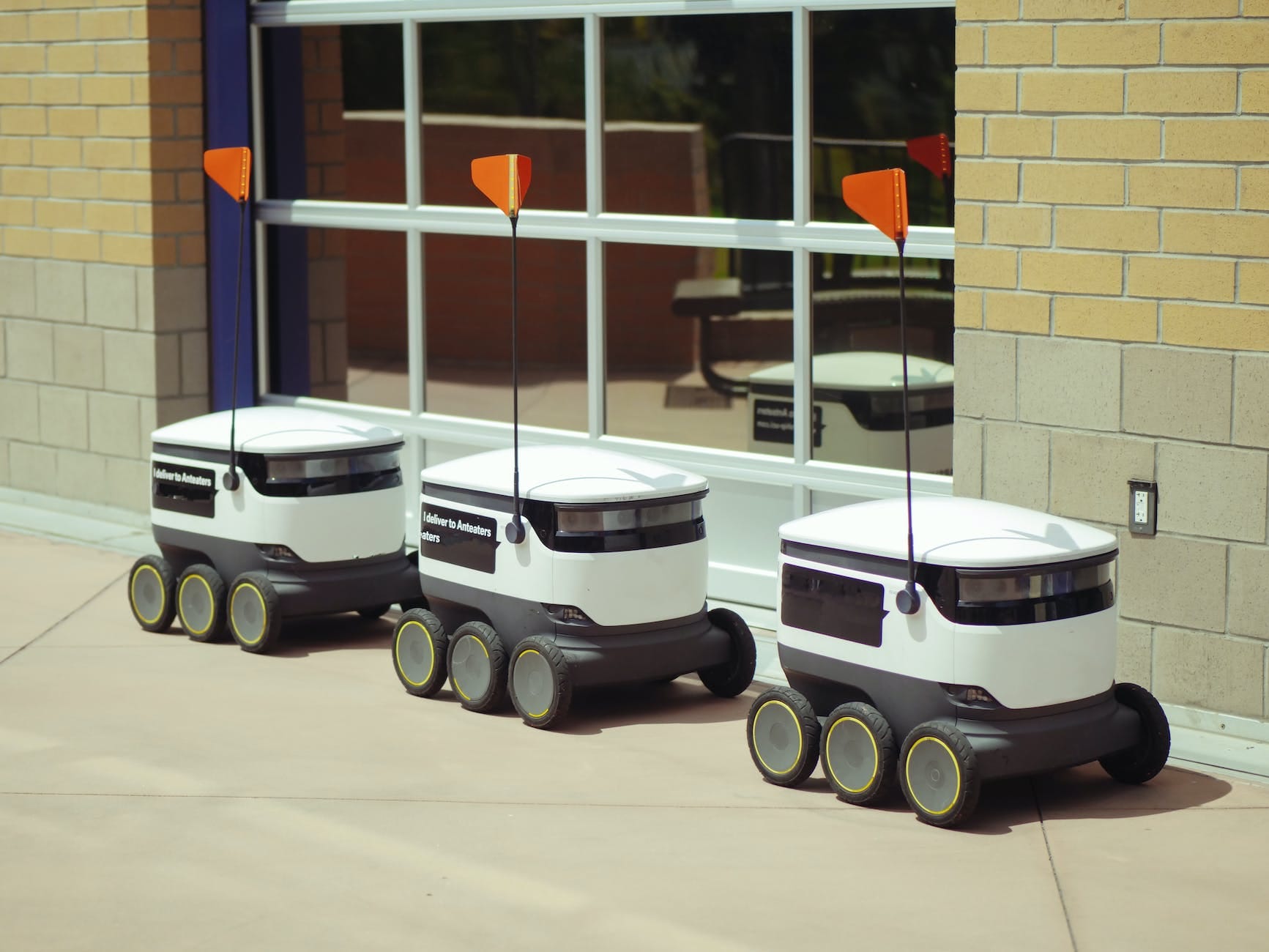 delivery robots parked beside glass window