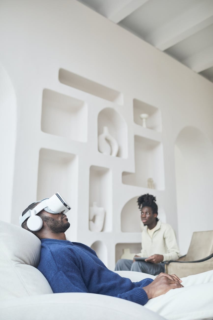 a man in blue sweater relaxing on a chair while wearing virtual reality headset